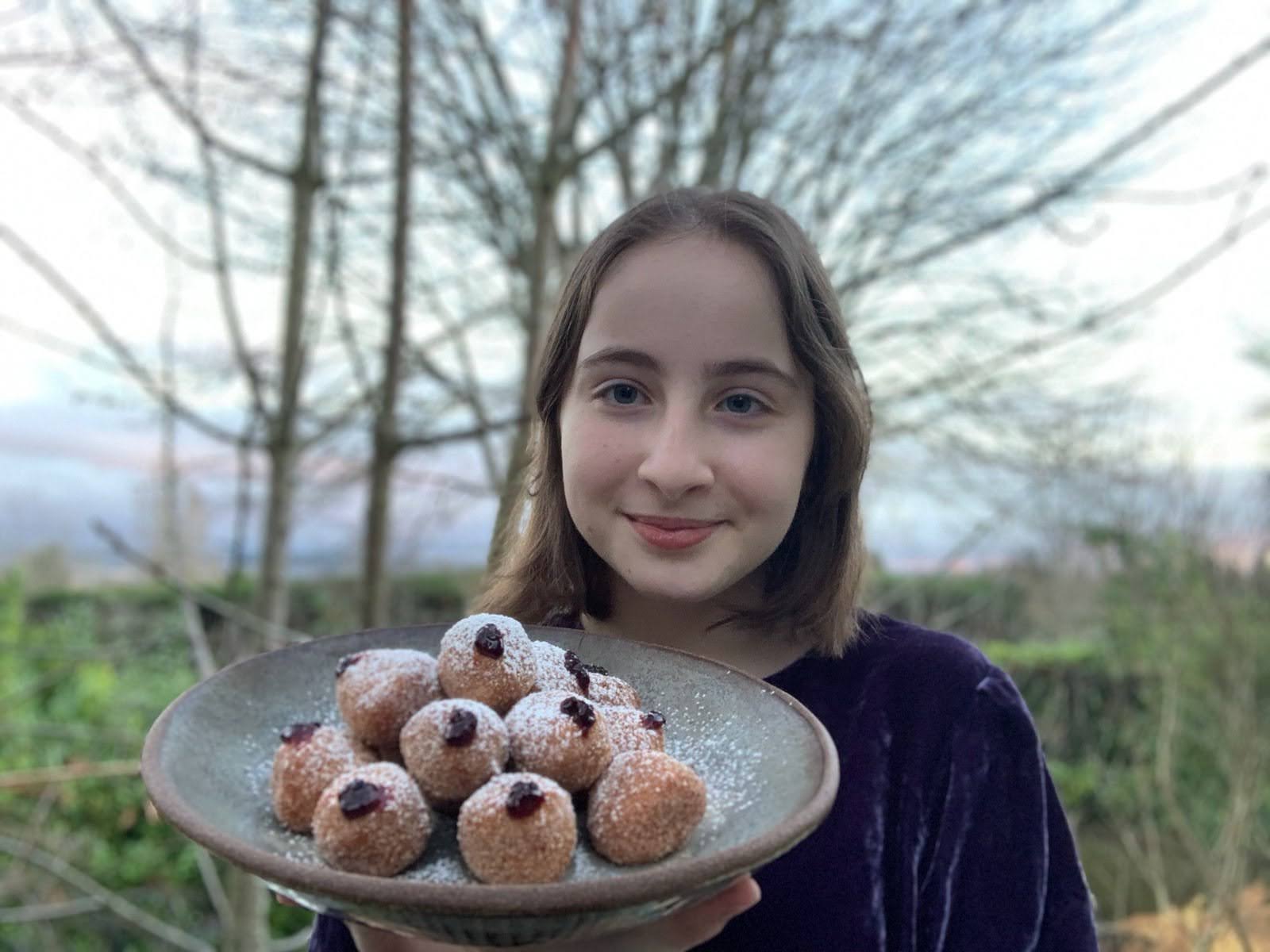 Sadie Suskind MAsterChef Junior holding jelly doughnuts her favorite Hanukkah treat