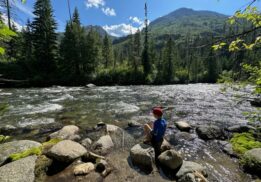 Boy sitting on a river at a state park in Washington.