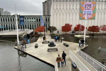 View of the Pacific Science Center courtyard with newly opened gates, showing families walking through the public space.