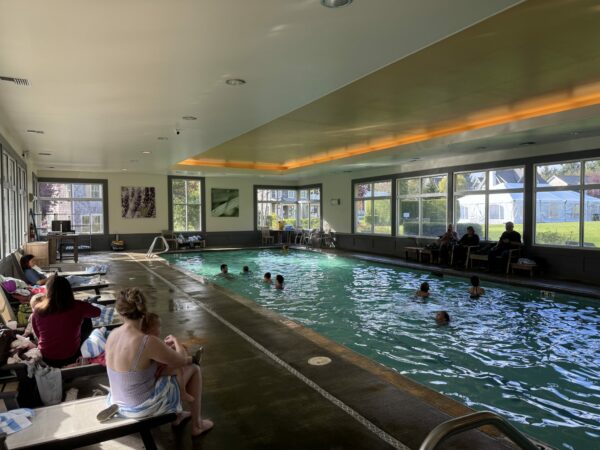 Families with young children swimming in Seabrook’s indoor heated pool, a bright space with large windows and shallow areas perfect for toddlers.