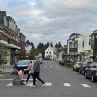 Seabrook’s town center on the Washington coast, showing pastel-colored shops, restaurants, and pedestrians walking along the main street on a sunny day.