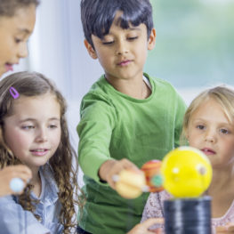 Kids exploring a model solar system during a Seattle-area midwinter break science camp