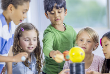 Kids exploring a model solar system during a Seattle-area midwinter break science camp