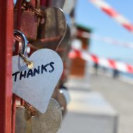 Heart-shaped keychain on a bridge engraved with the word “Thanks,” symbolizing gratitude and appreciation.