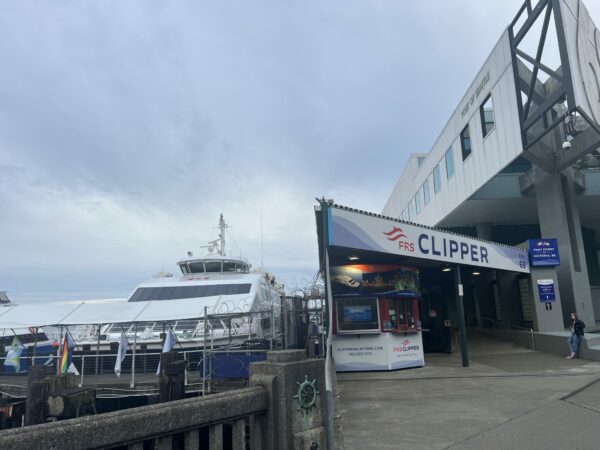 Pier in Victoria with sign for the Clipper next to large Clipper boat